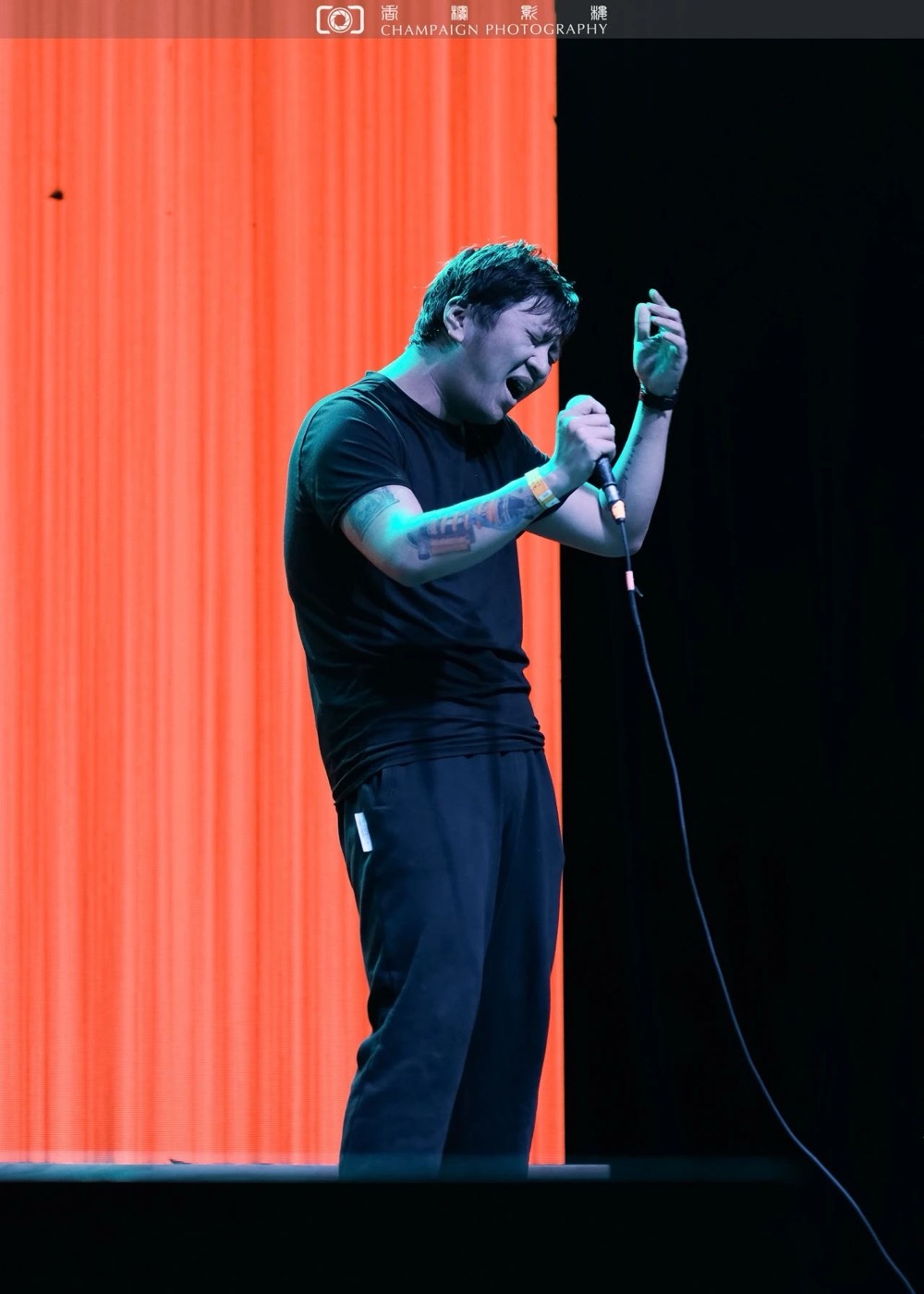 Edward performing against orange and blue stage lights