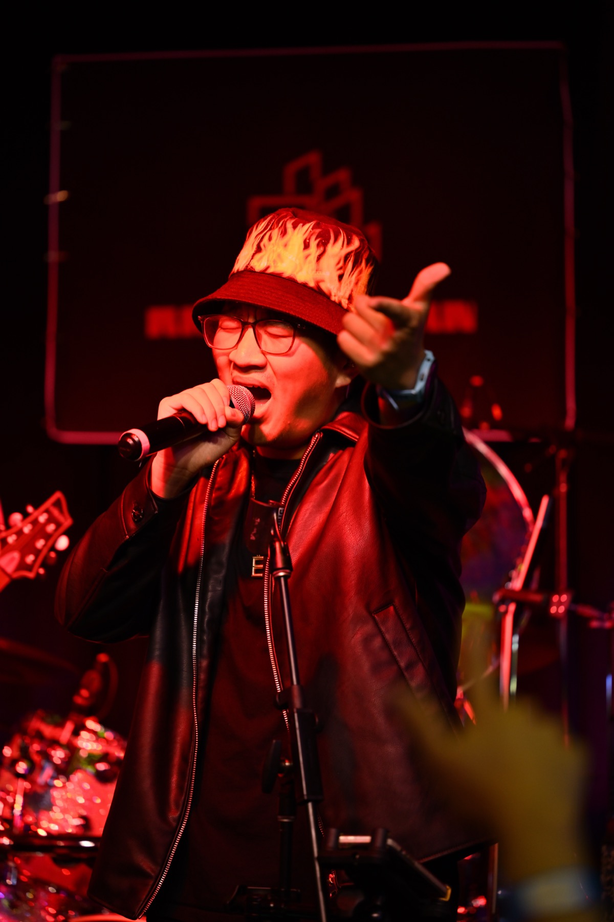 Edward singing into a microphone under red stage lights